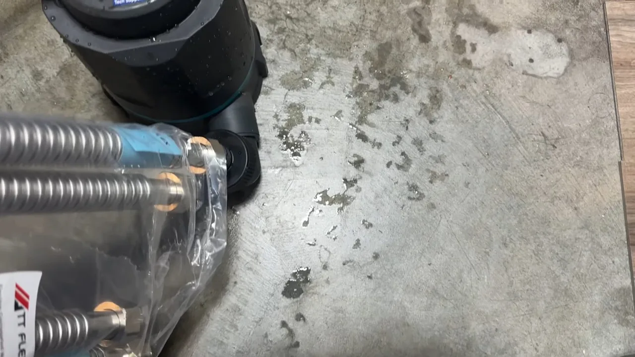 Braided stainless flexible connectors in a clear bag on a concrete floor beside a black fitting
